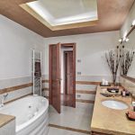 interiors of a modern bathroom in the foreground on the right the sink cabinet with integrated in the marble top two sinks on the left side there is a whirlpool bathtub